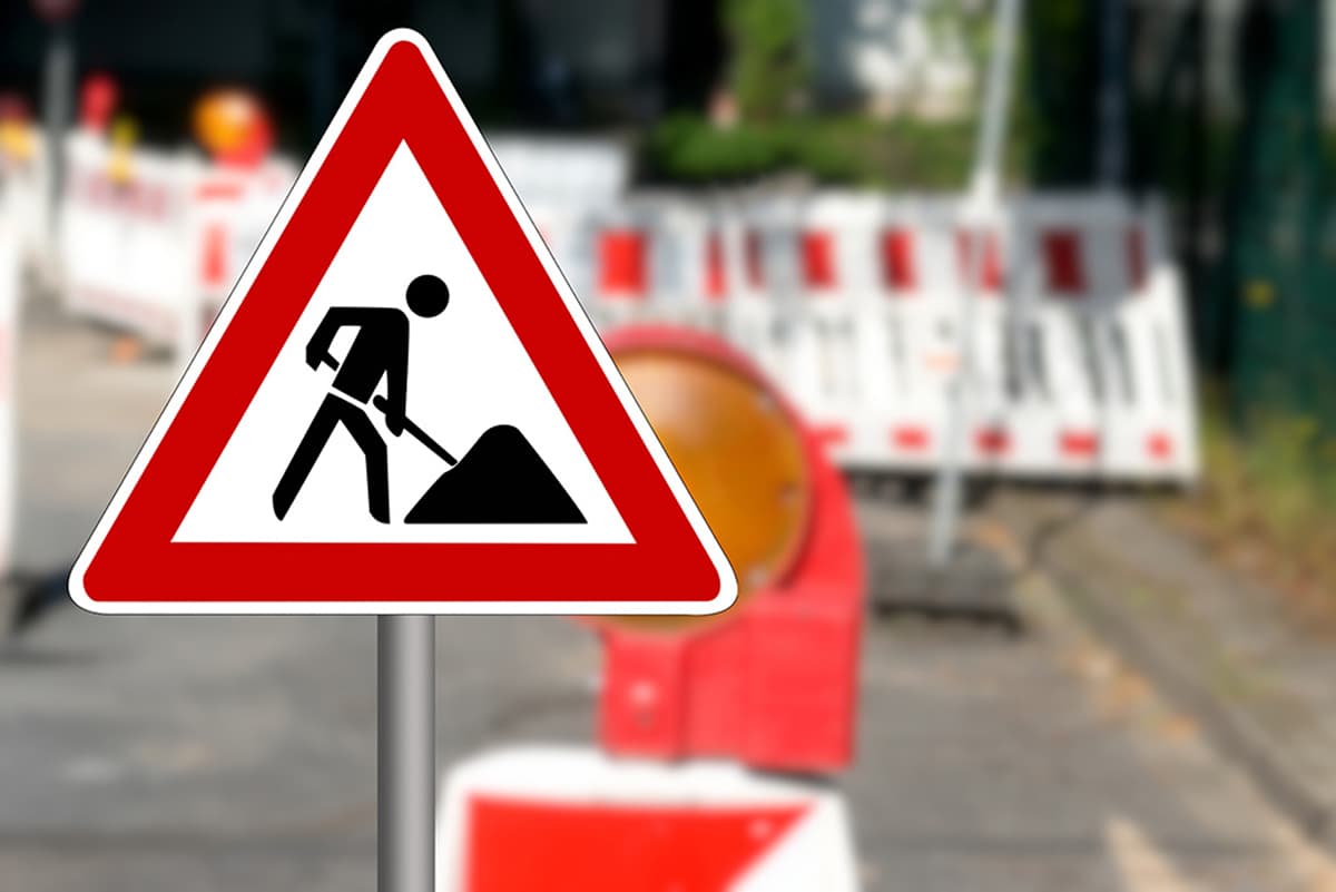 Baustellenschild vor Absperrungen auf einer Straße